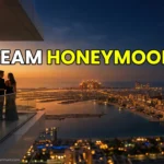 A couple standing on a private luxury terrace in Dubai watching the sunset over the Palm Jumeirah.