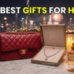 A luxurious display of Valentine's Day gifts including a red Chanel bag, diamond jewelry, and roses with the Dubai skyline in the background.